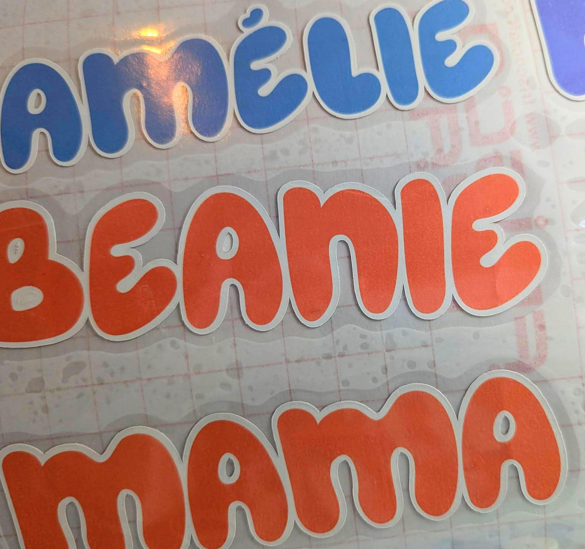 Custom name iron-on transfers printed in bubbly blue and orange letters