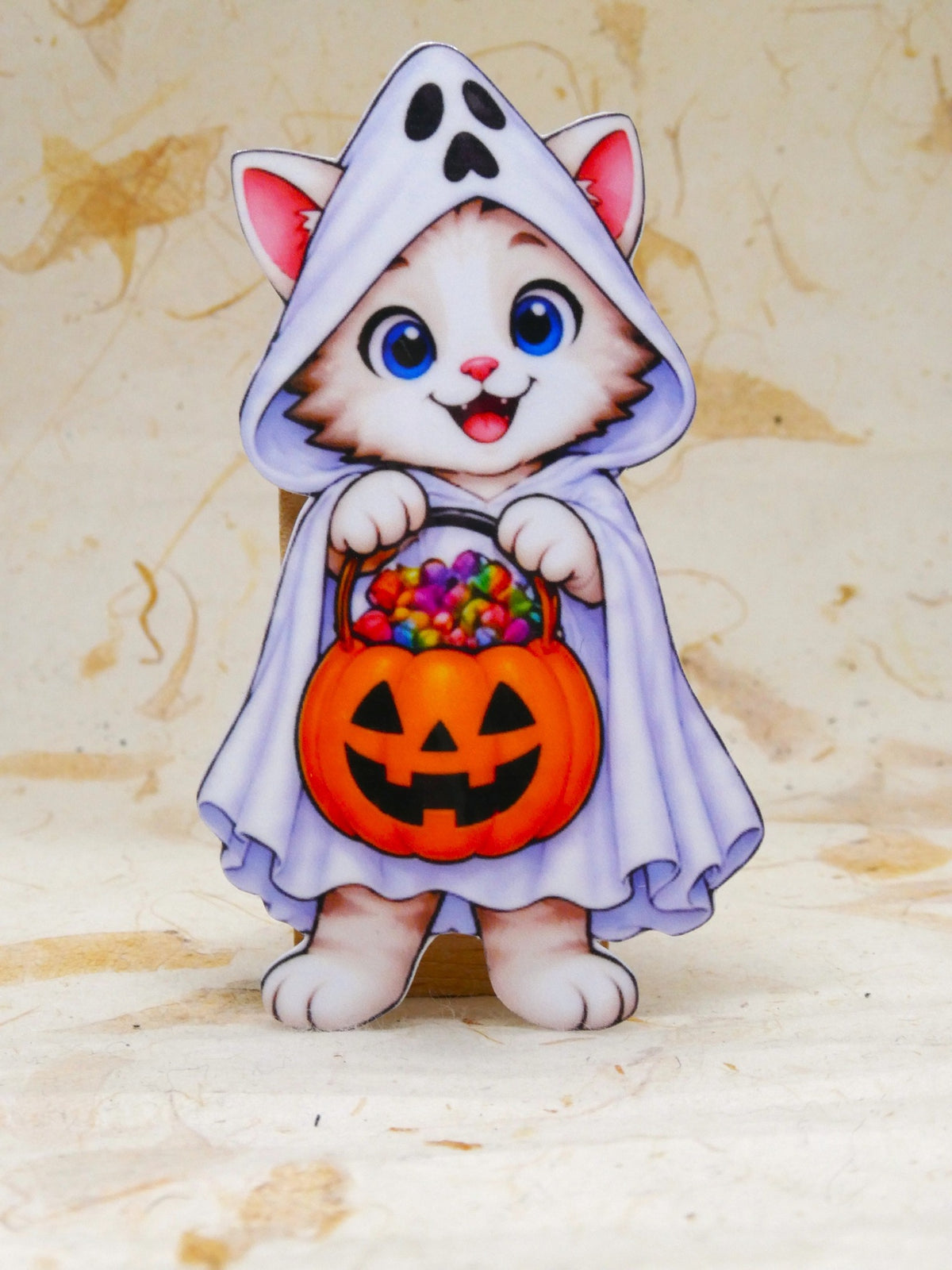 Ghost Bobcat Halloween sticker - kitten in a ghost costume holding a pumpkin candy bucket