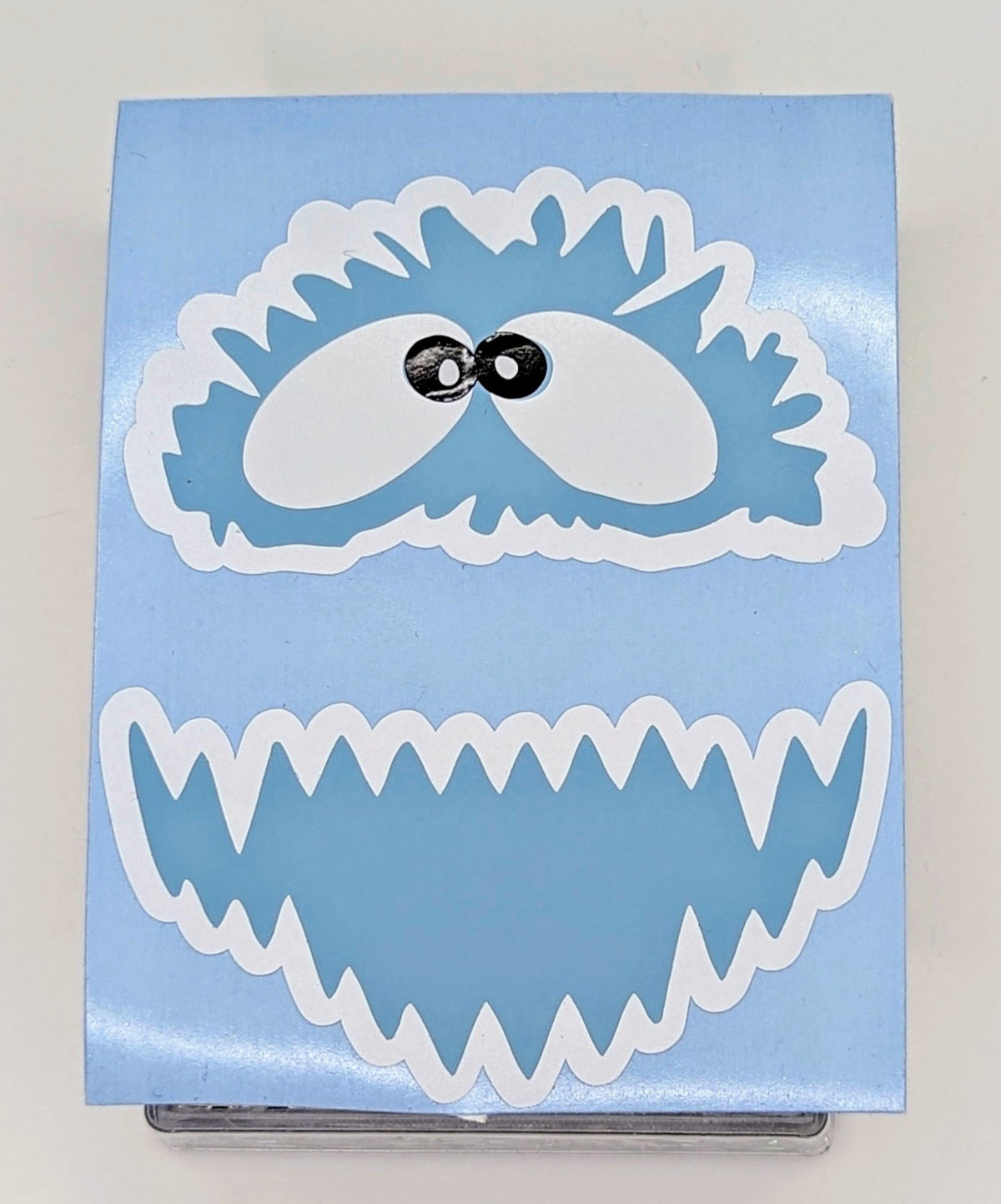 Yeti face vinyl decal in light blue, white and black on transfer backing